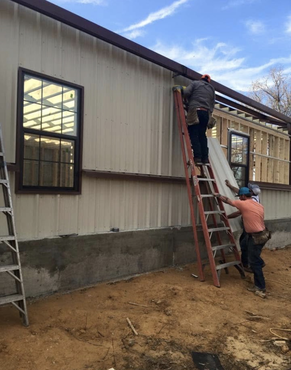 Whit-Tom crew installing metal siding around framed windows