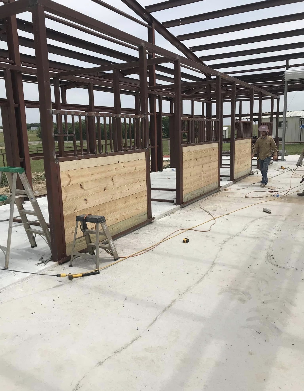 Custom red-iron stall framing with wood-lined lower walls
